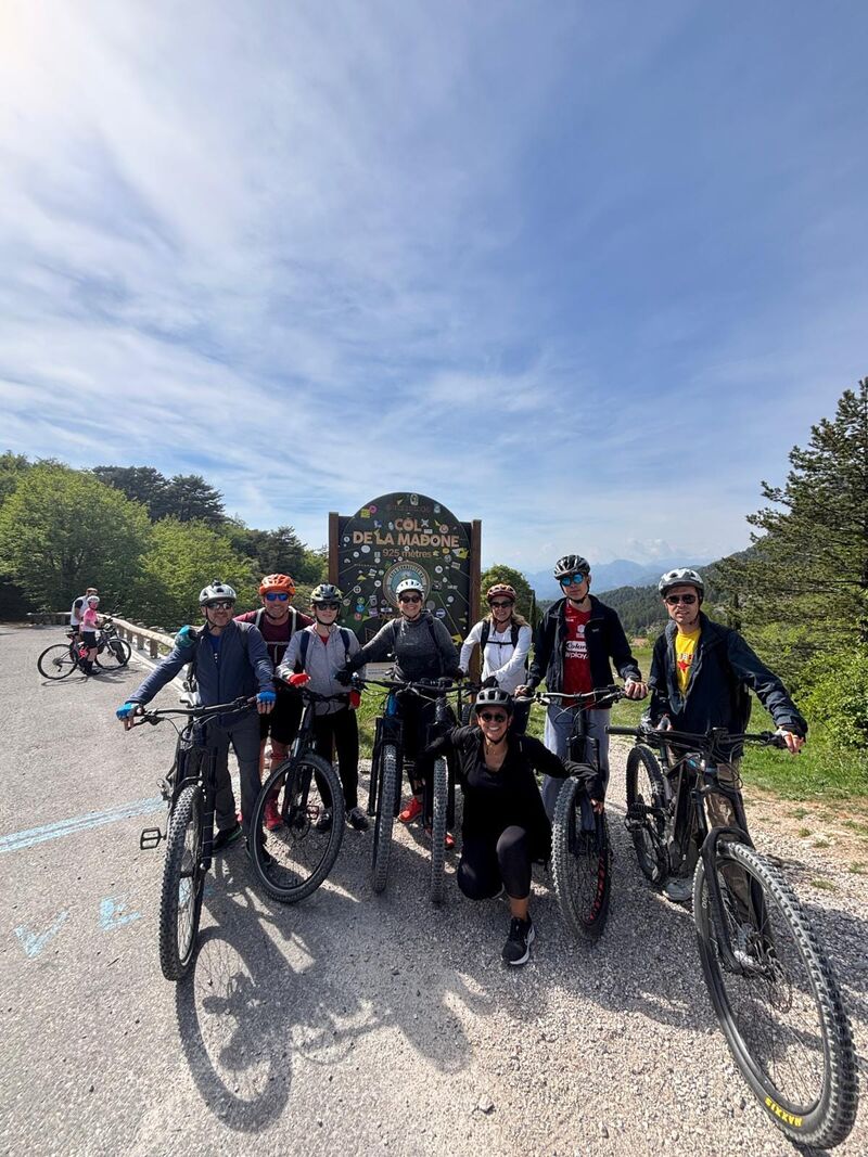 Une cycliste remontant une piste blanche entre les rochers calcaires et la garrigue